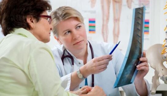 un medic examinează o radiografie pentru dureri de spate